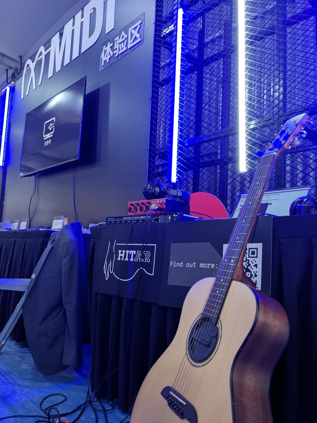 Our desk at the MIDI Association booth. Guitar on a stand with desk and HITar logo.